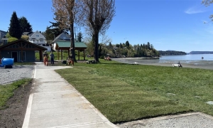 A photo showing the paved pathway to the washroom and picnic shelter at Kin Beach Park