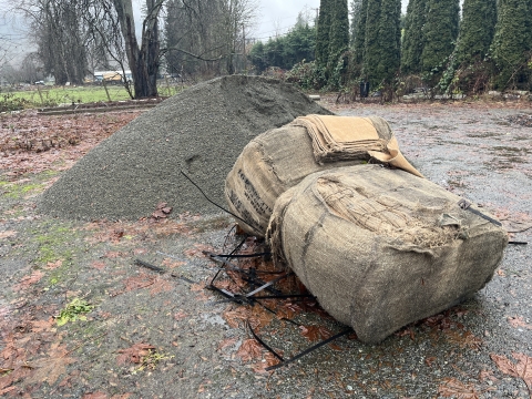 Pile of sand and stack of empty sandbags at Pinsons Corner